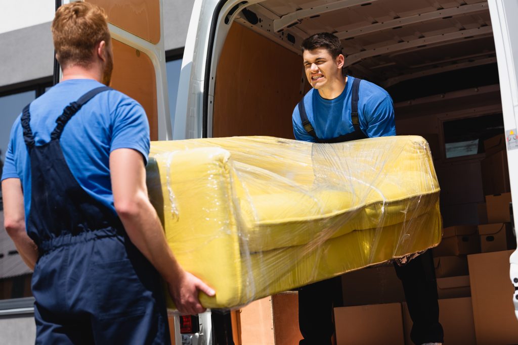 foyer selectif demenageurs dechargeant canape dans pellicule etirable dans camion exterieur scaled